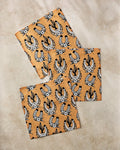 Three pieces of Cole Strem’s Western Horseshoes faux leather, made from recycled materials and featuring a black and white pattern of horseshoes, stars, and western hats, are displayed on a light marble surface.