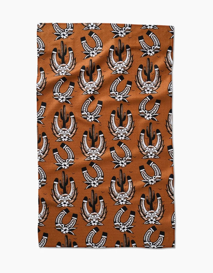 The Cole Strem Western Horseshoes rectangular tea towel, made of ultra-absorbent Geoweave fabric, features a repeating black and white horseshoe and feather pattern, shown flat against a white background.