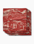 Geometry’s “Western Scene” napkin is a red, recycled dinner napkin featuring a white line drawing of mesas, horses, and desert plants. The eco-friendly napkins are stacked neatly with the design prominently displayed.