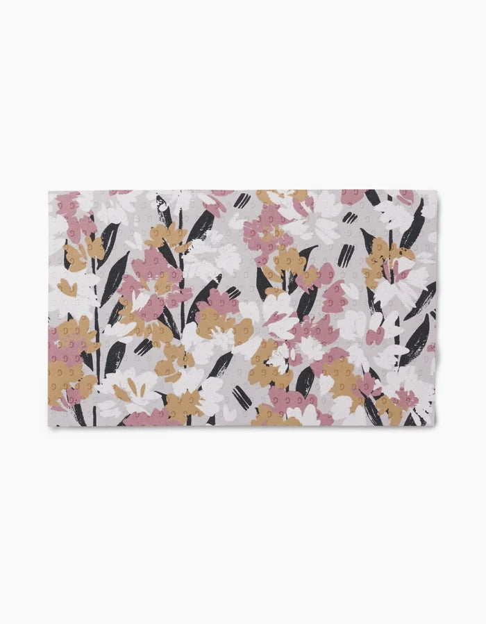 Wilderness Floral by Toboggan Avenue is a reusable, rectangular fabric towel with a painterly floral pattern in pink, mustard yellow, white, and black on light gray—an eco-friendly alternative to paper towels.