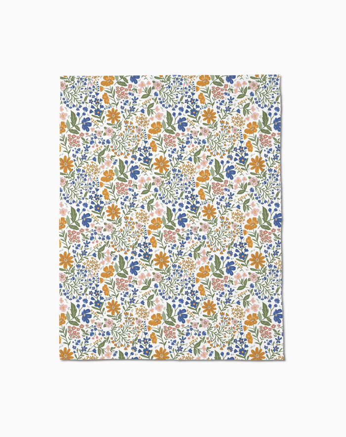 Wildflower Vine Blush by Danelys Sidron: a flat sheet of paper with a colorful floral pattern—orange, blue, and pink flowers with green leaves on white—densely arranged and inspired by the silky softness of Butter Blankets.