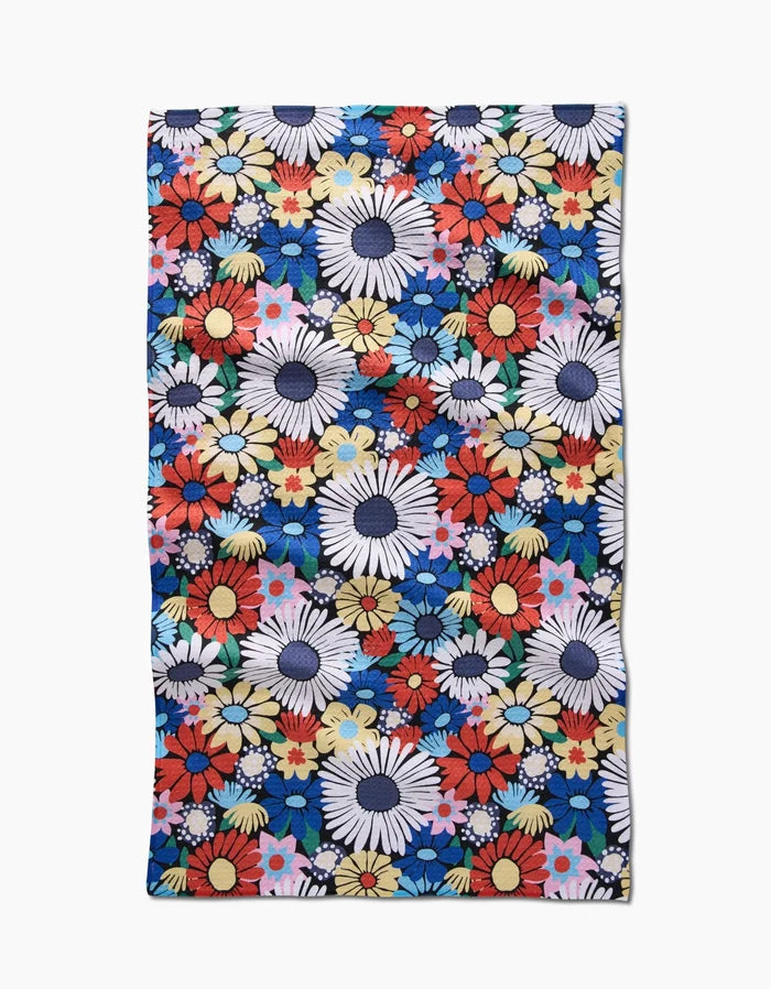The Wildflowers Bouquet Tea Towel by Claire Iglesias features a dense floral pattern in white, red, yellow, pink, and blue on dark blue Geoweave™ fabric for superior absorbency.