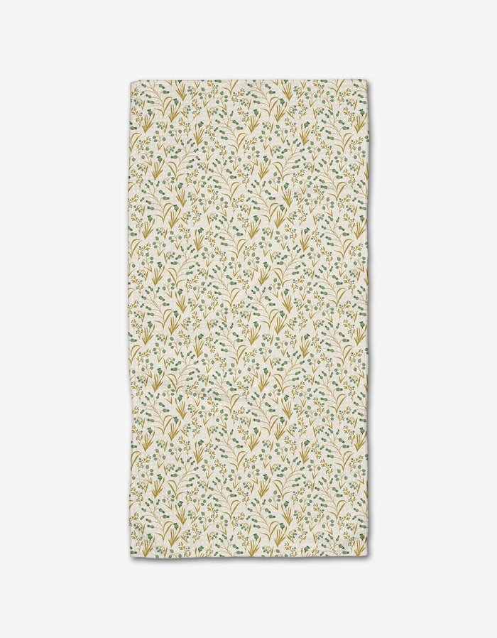 The Wildlight bar towel by Danelys Sidron features a delicate yellow and green floral and leaf pattern on white, crafted from recycled materials.