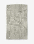 The Willow Branches tea towel by Katie OShea features a light gray background with vertical, wavy lines and scattered white dots, evoking the look of stylized branches or vines.
