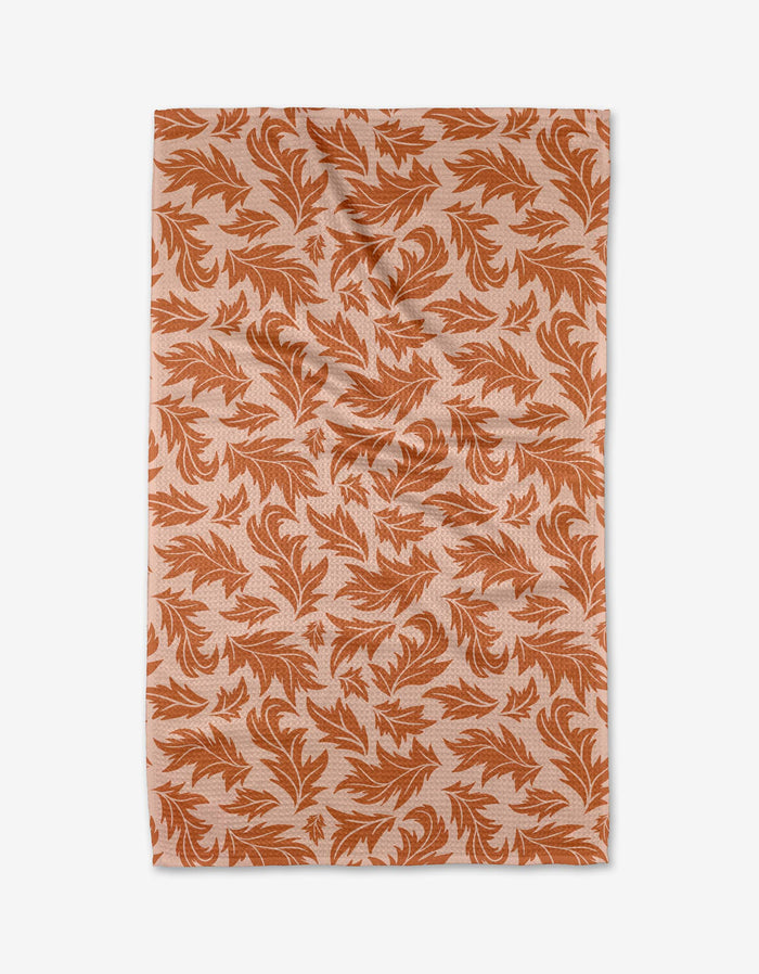 The Wind Fall by Danelys Sidron is a rectangular, ultra-absorbent fabric featuring an orange leaf pattern on a light beige background, shown laid flat with slight wrinkles.