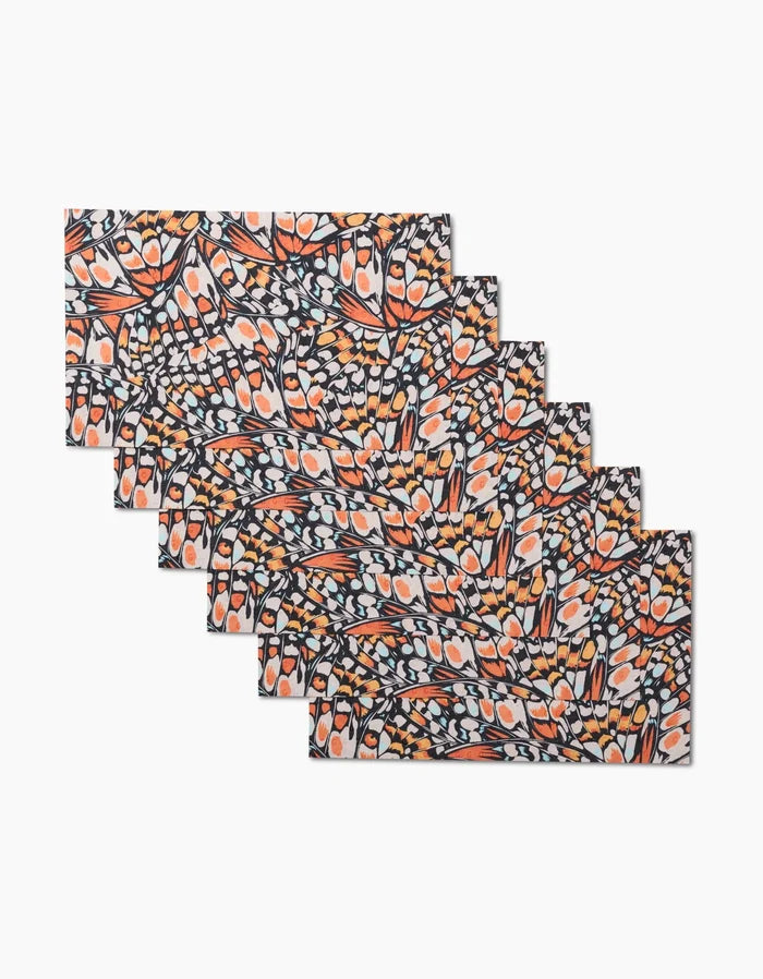 Six Wings in the Wind rectangular placemats by GEOMETRY, featuring colorful orange, white, and navy abstract shapes, are arranged in a fanned stack. Made from economical, eco-friendly post-consumer recycled materials.