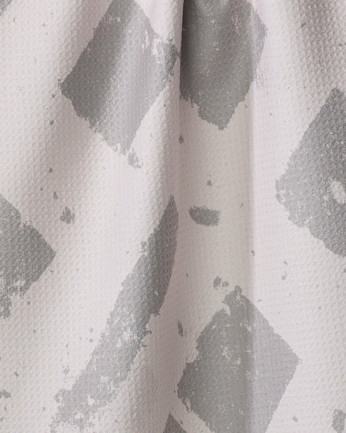 Close-up of the Wisp Gray towel by Geometry, showing its ultra-absorbent textured fabric with an abstract pattern of irregular gray brushstrokes overlapping on a light background.