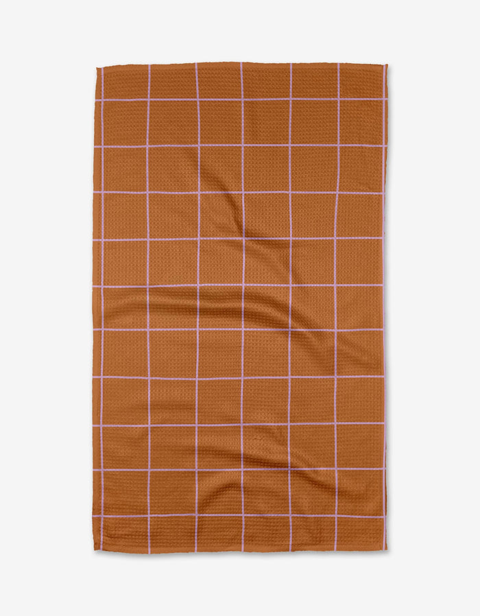 The Beetle Ink Co. Wonky Grid is a brown rectangular tea towel featuring thin white grid lines, shown flat on a white background. Ultra-absorbent, it’s perfect for everyday kitchen use.