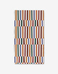 The Claire Iglesias Wonky Stripes textile showcases vertical orange, green, blue, red, and mustard stripes with a wavy geometric pattern on white, crafted with ultra-absorbent Geoweave technology for superior performance.
