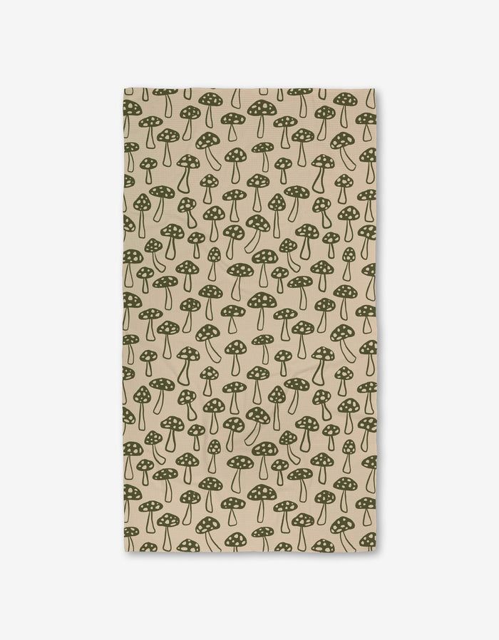 The Woodland Mushroom by Kayla Ann is a beige rectangular cloth with a green dotted mushroom pattern, evenly spaced and made from ultra-absorbent recycled materials.