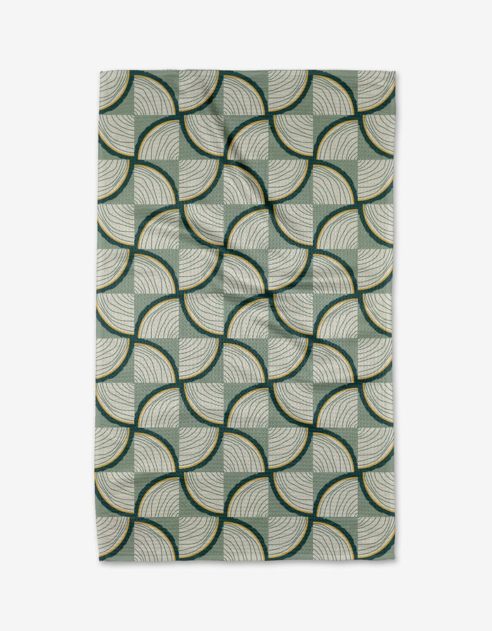 The Twig + Spark Woodpile rug features fan-shaped geometric arcs in green, cream, and dark yellow on a light background—perfect for pairing with an eco-friendly tea towel in your kitchen décor.
