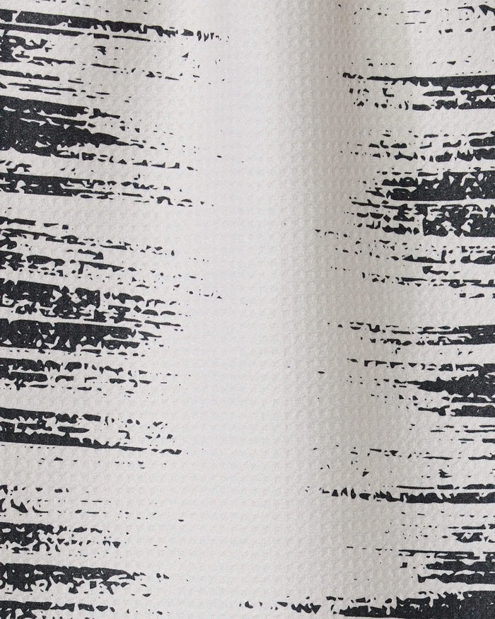 Close-up of the Worn Edges towel by GEOMETRY shows a textured white surface with irregular black lines, resembling a distressed or painted pattern typical of ultra-absorbent or recycled kitchen towels.