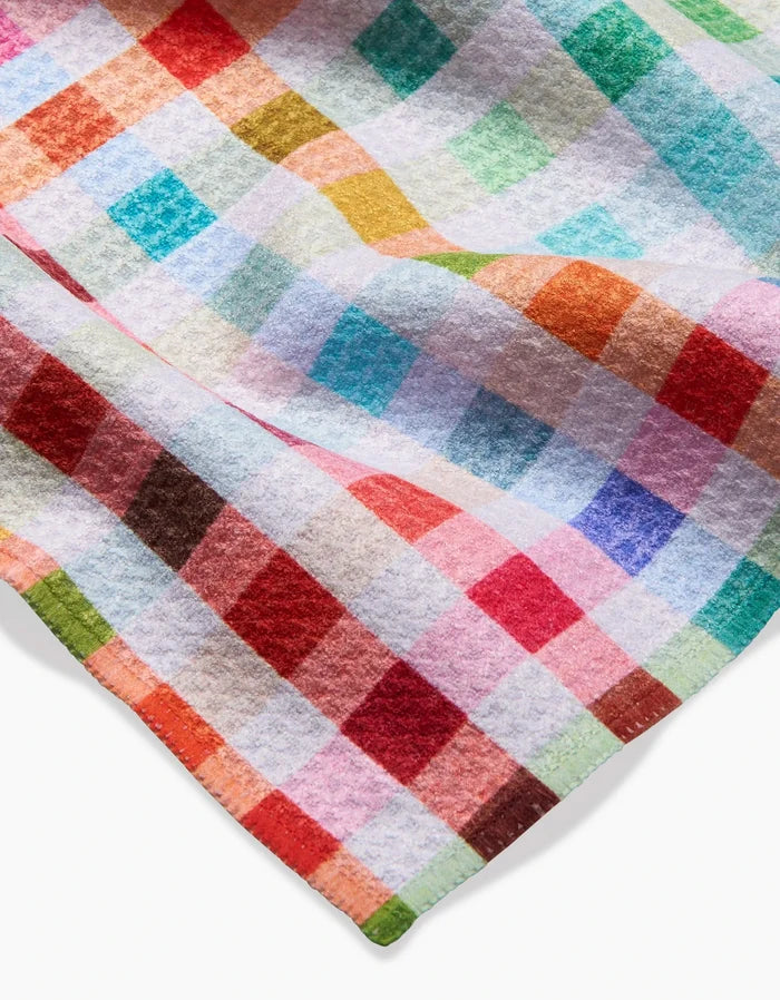 A close-up of Pascale Dilgers Woven Spring Plaid Bar Towel, made from recycled materials and featuring a colorful checkered pattern in red, orange, green, blue, pink, and white on soft, textured fabric with visible edges.
