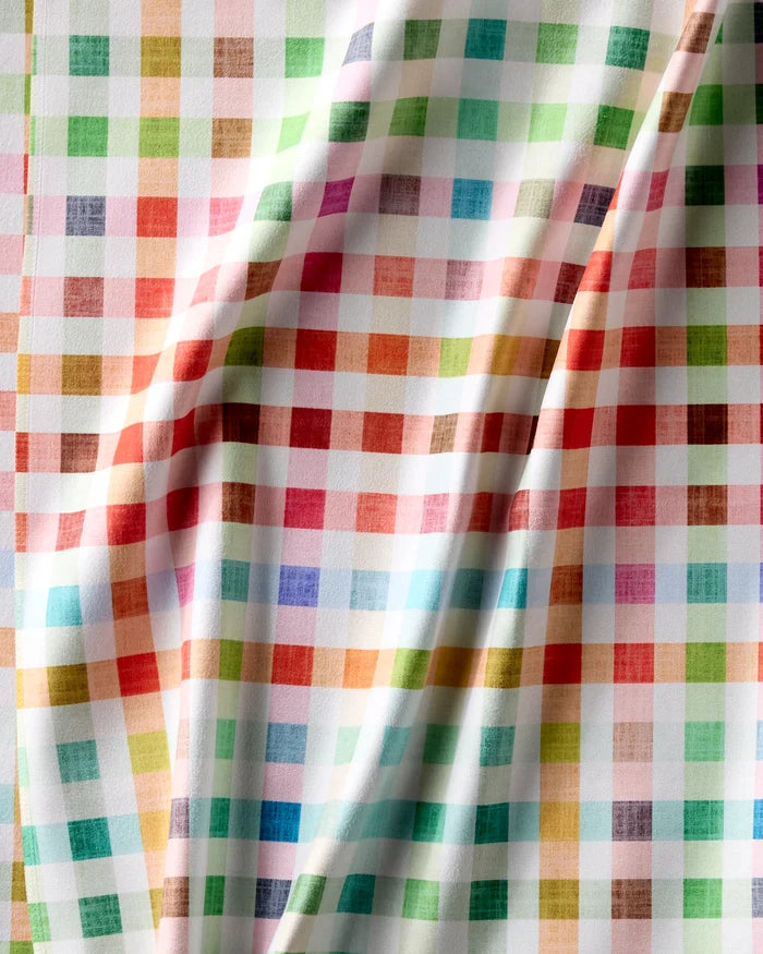 A close-up of Pascale Dilger’s Woven Spring Plaid recycled dinner napkins shows their absorbent, colorful checkered pattern in red, green, blue, orange, and brown with soft folds and shadows.