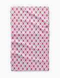 The XOXO towel by Sarah Daugherty is a rectangular, quick-drying towel with pink and red X and O letters in neat rows on a white background. It features a soft, absorbent texture and subtle fabric creases.