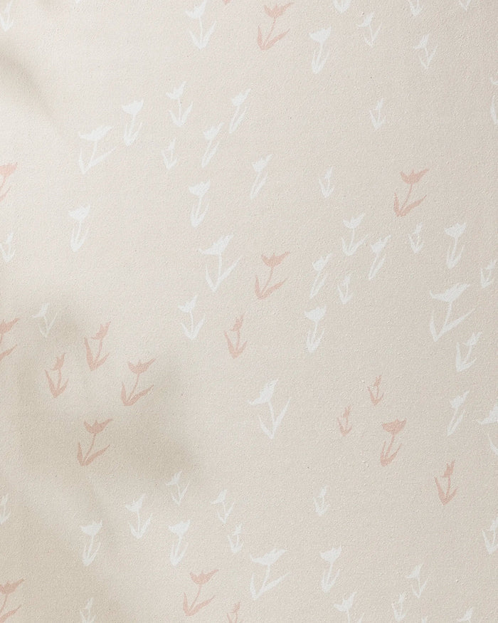The Aubrey Fairchild "You Grow Girl" yoga towel is beige and slip-resistant, featuring a subtle pattern of small hand-drawn white and light pink flowers scattered across its surface.