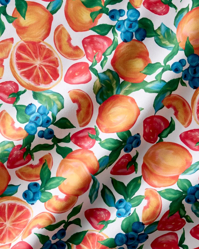 Aubrey Fairchild's Zesty Life Dinner Napkin Set features absorbent cloth napkins decorated with lively peach, grapefruit, blueberry, and strawberry illustrations on a white background—perfect for any occasion.