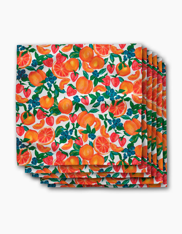 The Aubrey Fairchild Zesty Life Dinner Napkin Set features a vibrant fruit pattern with oranges, strawberries, blueberries, and grapefruit on white, crafted from post-consumer recycled materials.