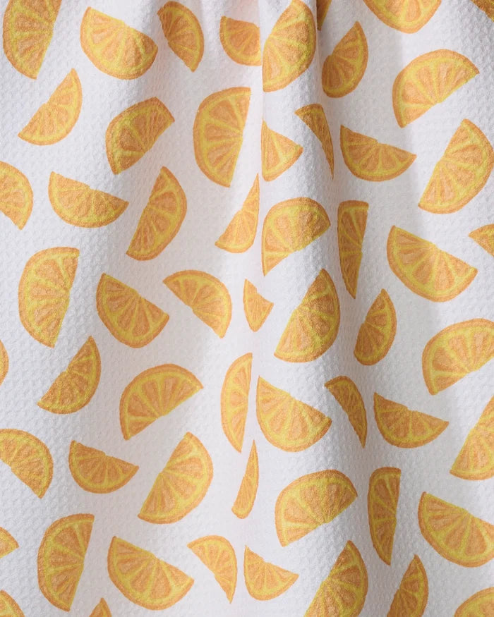 The Zesty Slice kitchen towel by Aubrey Fairchild features a white textured fabric with yellow and orange lemon wedge patterns at various angles. Made from recycled materials, it adds an eco-friendly accent to your kitchen.