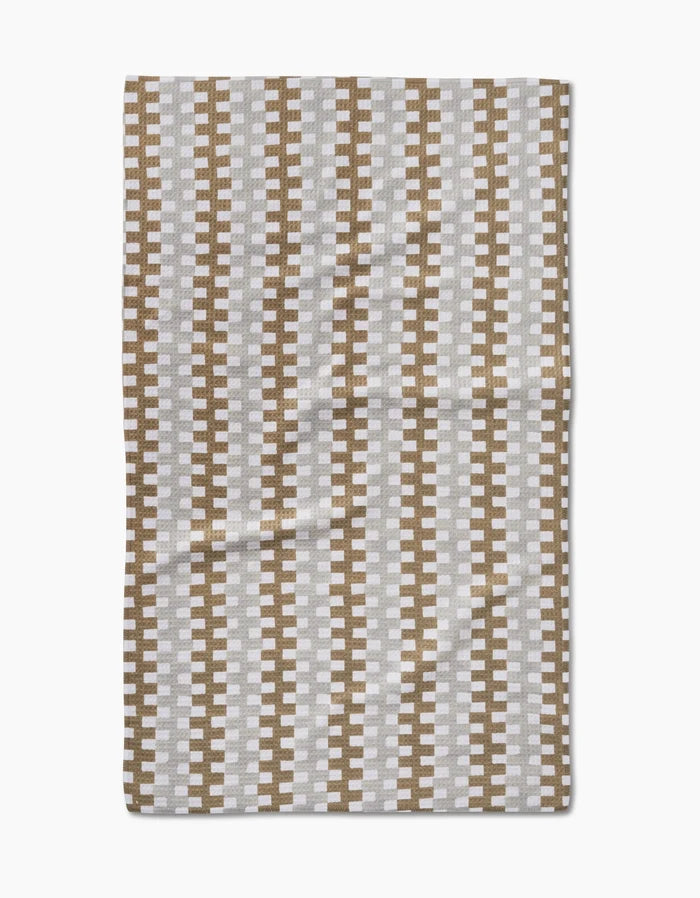 The Studio Jeannot Zippy is a rectangular ultra-absorbent dish towel featuring a repeating geometric pattern of vertical brown and white zigzag stripes on a light background, shown laid flat.